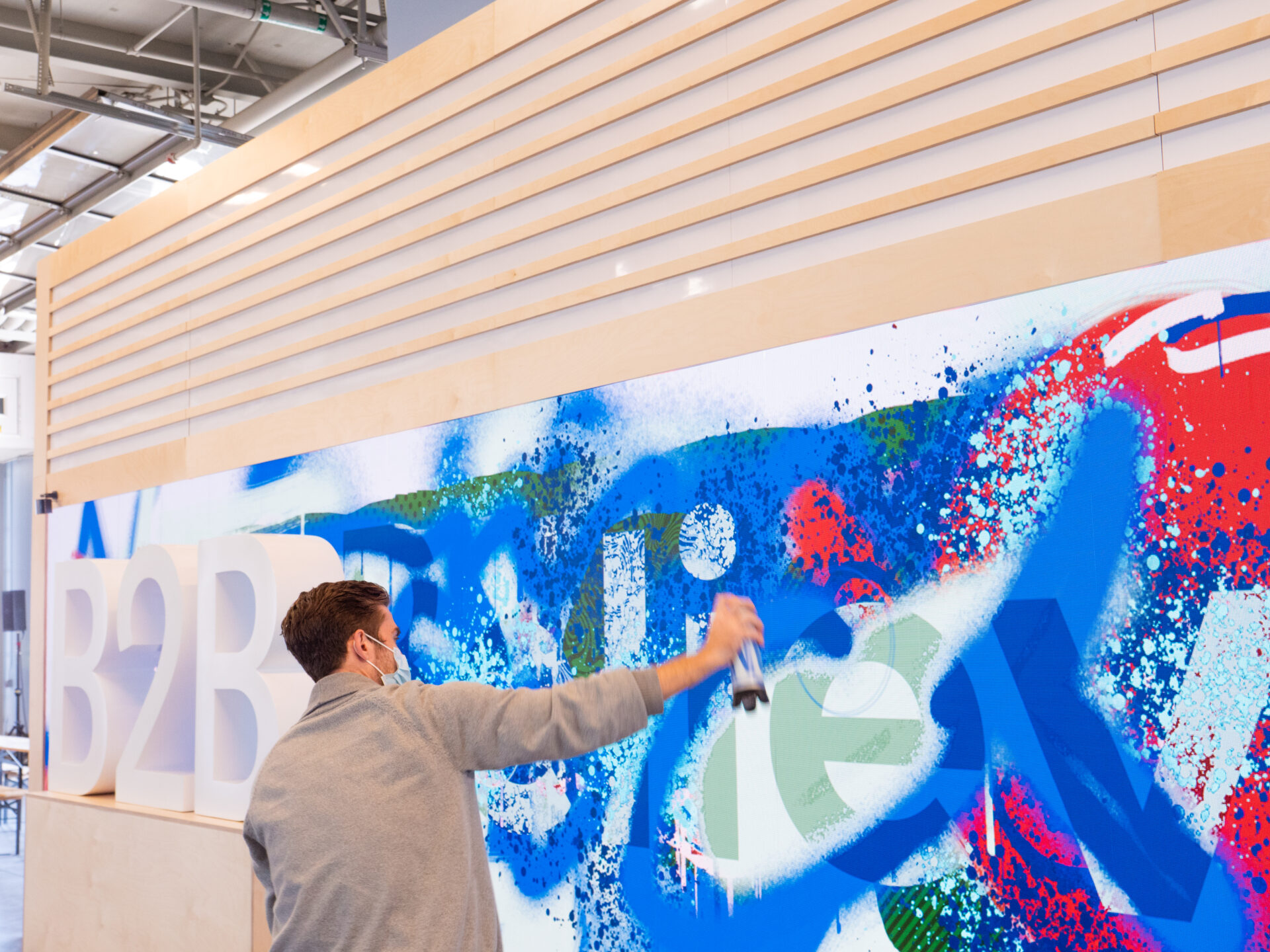 A person spraypainting on the LED wall.